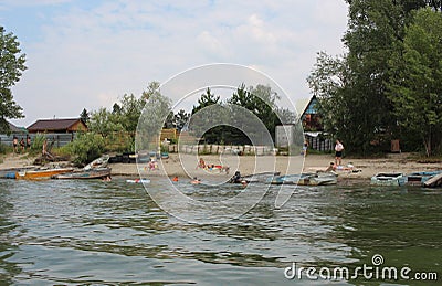 Russia, people relax on the beach swim in the river in the summer swim with boats on the shore Editorial Stock Photo