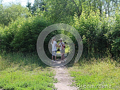 Two girls friends walking on the street go through the Park Editorial Stock Photo