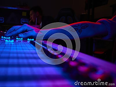 russia october 2020. Close-up of hand's sound engineer working on music mixer in the recording studio. low light color Editorial Stock Photo