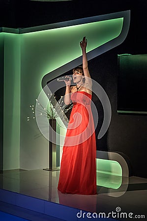 Russia, Ryazan - 30.06.2014: Beautiful girl standing with microphone passionately singing with closed eyes Editorial Stock Photo