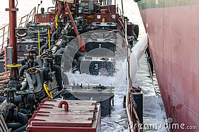 Discharge of ballast water on the deck of an oil tanker in the bay in the port Editorial Stock Photo
