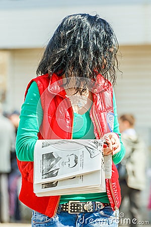 Young beautiful girl gives out a free newspaper Editorial Stock Photo