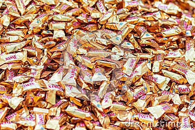 Caramel candy Twix on store shelves, texture. Text in Russian: caramel candy Editorial Stock Photo