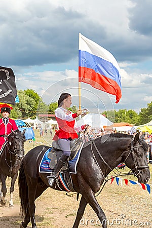 Solemn entry of a group of horse racing with flags in the meadow of the festival Editorial Stock Photo