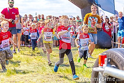 children in a sports uniform are worried before the start in city competitions to overcome obstacles. Text in Russian: race of he Editorial Stock Photo