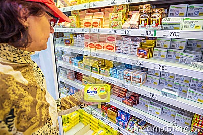 beautiful mature women choose butter in the store. Editorial Stock Photo