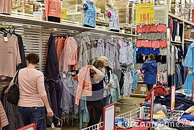Buyers measure clothes in the supermarket Editorial Stock Photo