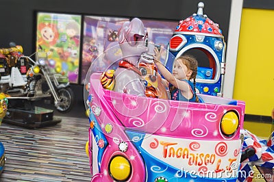 Russia, St. Petersburg, 06/22/2019. Little girl rides on the children`s carousel in the hypermarket Editorial Stock Photo