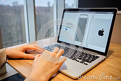 RUSSIA, ST.PETERSBURG - March 5: A girl browses an apple site on a laptop. Looking for mac pro Editorial Stock Photo