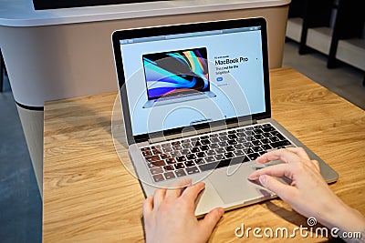 RUSSIA, ST.PETERSBURG - March 5: A girl browses an Apple site on a macbook. Looking for macbook Editorial Stock Photo