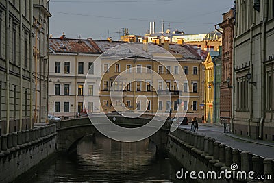 Russia, St. Petersburg, a narrow water channel between houses, a bridge, beautiful lighting. Summer city view, warm yellow houses Editorial Stock Photo