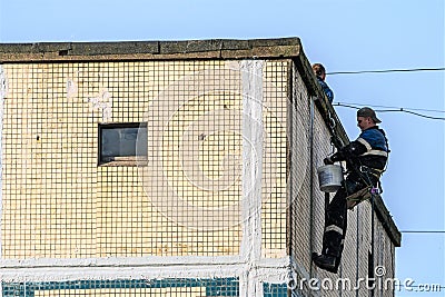 Russia, St. Petersburg, September 2020. Workers on the roof of a multi-storey residential building. Editorial Stock Photo