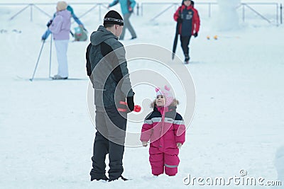 05.01.2020, Russia, Syktyvkar: Little girl with her father stand against snowy street Editorial Stock Photo