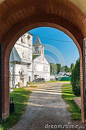 Russia, Uglich, July 2020. View of the road to the Orthodox monastery through the arch of the entrance. Editorial Stock Photo