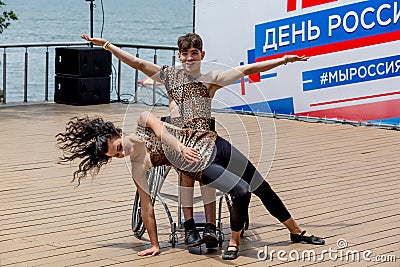 Russia, Vladivostok, 06/12/2018. Actor in wheelchair and usual actor perform the dance on stage. Annual celebration Russia Day on Editorial Stock Photo