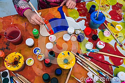 Russia, Yaroslavl city - May 4, 2019: The child holds a brush. Coloring a wooden board. Creative studio or drawing lesson. Stock Photo