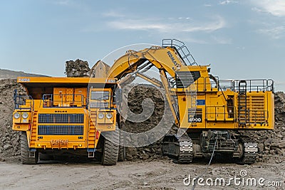 Komatsu PC4000 electric excavator loads ore mass into BelAZ dump truck. The action takes Editorial Stock Photo