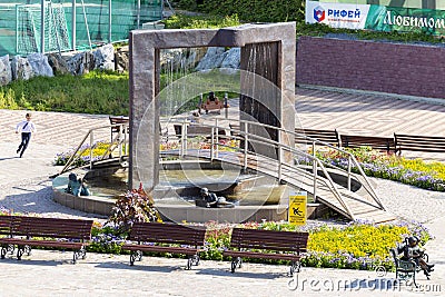 Krasnaya Gorka, Bazhov Mountain Park. Children reading a book on a summer day. Russian text: Riphean building machinery factory, Editorial Stock Photo