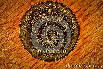 Russian coin of golden alloy. Revers with seal of Bank of Russia depicting twin headed eagle with heraldic signs. Words in russian Stock Photo