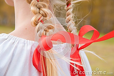 Russian girl Slavic appearance with braids with red ribbons in t Stock Photo