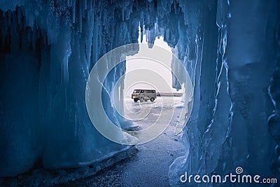 Russian local van on Baikal frozen lake in front of ice cave, Baikal in winter, Siberia, Russia Stock Photo