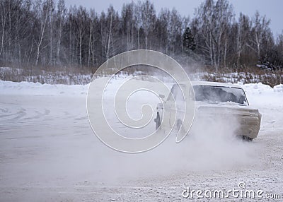 Russian modified old car `VAZ-Zhiguli` goes fast drift turning the wheels raising snow. Editorial Stock Photo