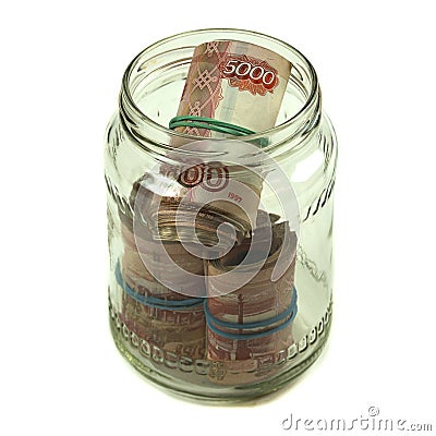 Russian money banknotes of five thousand rubles are rolled up and lie in a glass jar. Several packs of large rubles Stock Photo