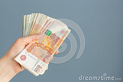 Russian, paper banknotes in their hands on a blue background Stock Photo