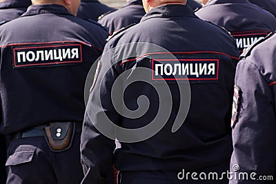 Russian police officers on patrol in the town square. View from the back. The inscription on the uniform: the police Stock Photo