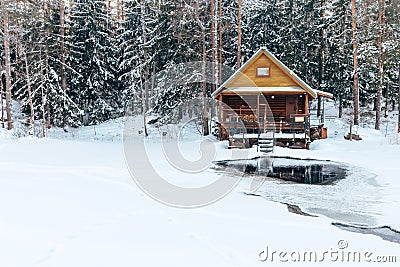 Russian sauna banja house in winter forest nearby the lake with ice-hole Stock Photo