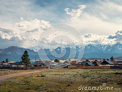 Russian siberian village with dirt road and traditional ancient wooden houses. Wooden houses in an old Siberian Kurai village. Stock Photo