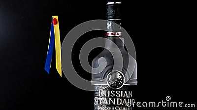 Russian Standard vodka with Ukrainian flag colors behind on black background Editorial Stock Photo