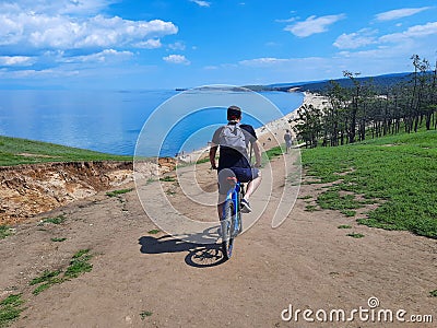 Russian tourist riding bike to the Saraysk bay with a sandy beach Stock Photo