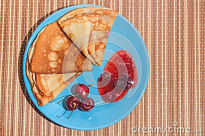 Russian traditional dish pancakes with cherries, jam and milk Stock Photo