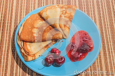 Russian traditional dish pancakes with cherries, jam and milk Stock Photo