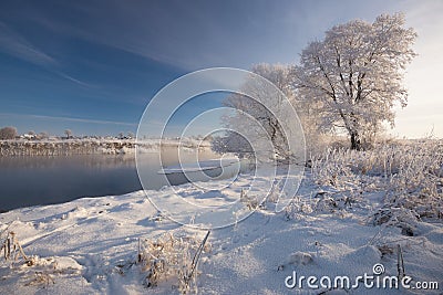 Russian Winter. Morning Frosty Winter Landscape With Dazzling White Snow And Hoarfrost,River And Saturated Blue Sky. Stock Photo