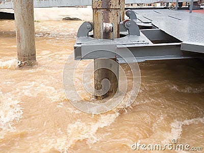 Rust roller support pole of pontoon in rapid stream flowing river Stock Photo