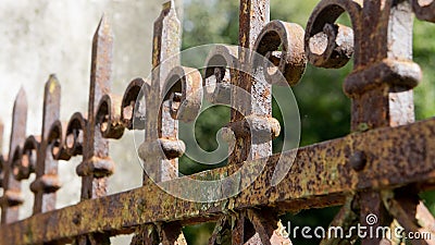 A rusted, decorated, wrought iron fence. Detail of an old retro iron fence made with decorated ironwork elements. Stock Photo