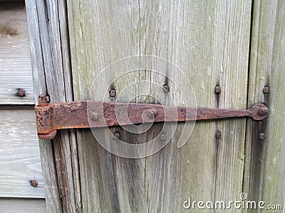 Rusted hinge and square nails on weathered wood Stock Photo