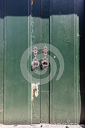 Rusted metal pulls on an old green door Stock Photo