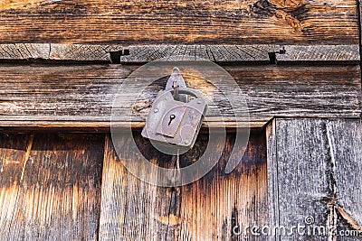 A rusted padlock on a wooden door Stock Photo