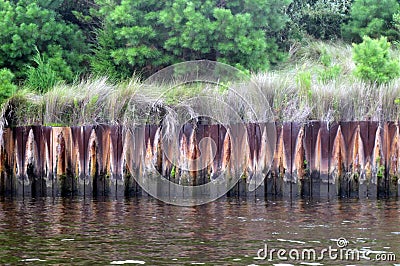 Rusted steel waterway barrier with grass, #2 Stock Photo