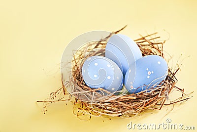 Rustic Blue Eggs in the Hay Nest on Yellow Background Stock Photo