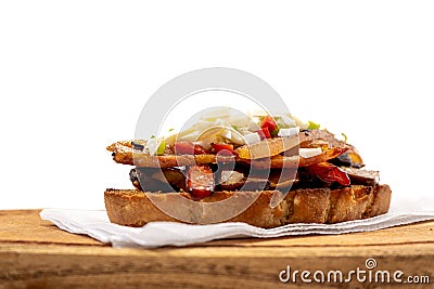 A rustic bread brusquette with mayonnaise, bacon, mushrooms and vinaigrette, drizzled with EVOO or olive oil. Typical Spanish tapa Stock Photo