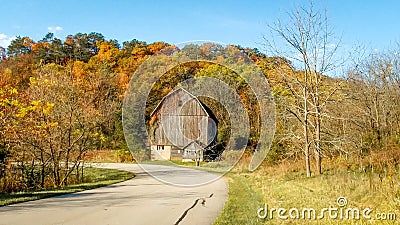 Rustic Brown Barn Amidst Fall Colored Trees Stock Photo