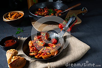 Rustic chicken wings in honey with potato wedges Stock Photo