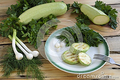 Rustic dinner with fried zucchini slices with greens. Stock Photo