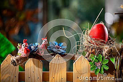 Rustic Easter Composition: Handcrafted Nest, Red Egg, and Whimsical Bird Figures Stock Photo
