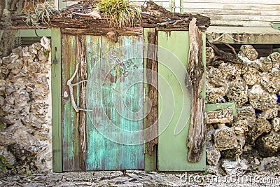 Rustic faded aqua garden doorway surrounded by a rock wall in Key West, Florida Stock Photo