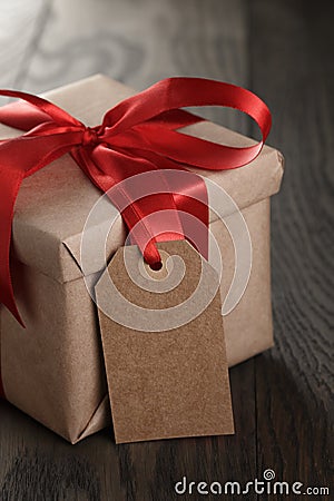 Rustic gift box with red ribbon bow and empty tag Stock Photo